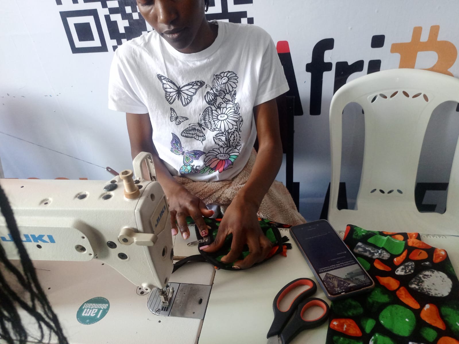 A worker handling fabric at a sewing machine in Kenya.