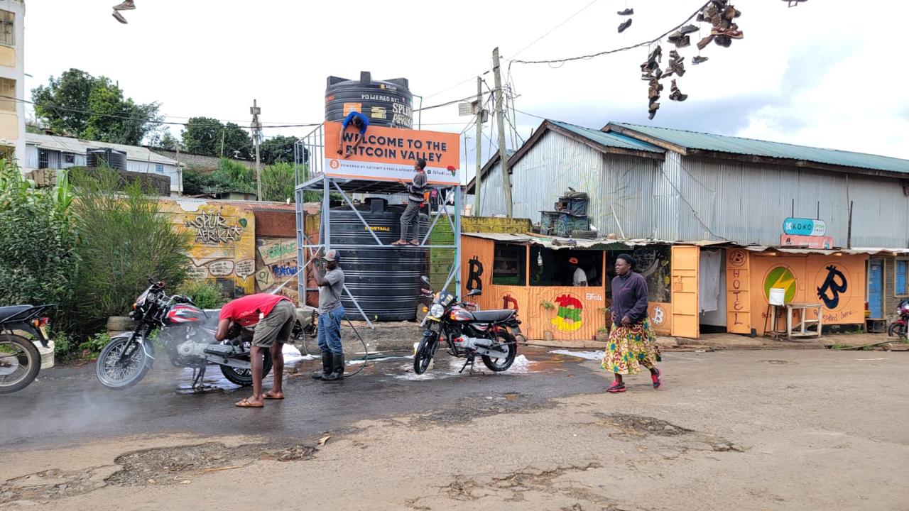Workers washing motorcycles at an outdoor workplace in Kenya.